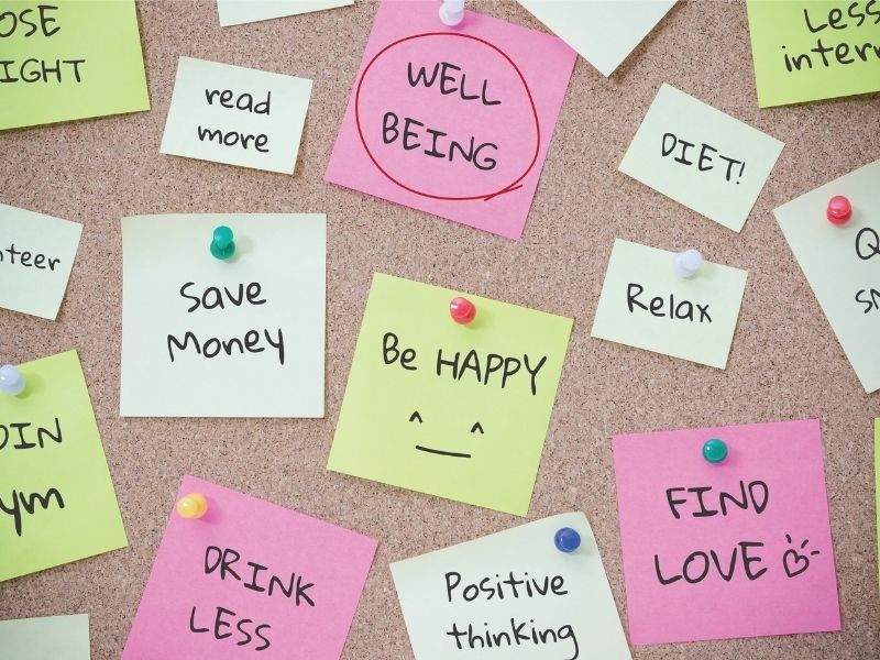 "A bulletin board covered in sticky notes with motivational messages and personal goals written on them, encouraging a positive mindset and self-improvement."