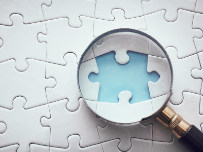 blue-puzzle-piece-on-magnifying-lens